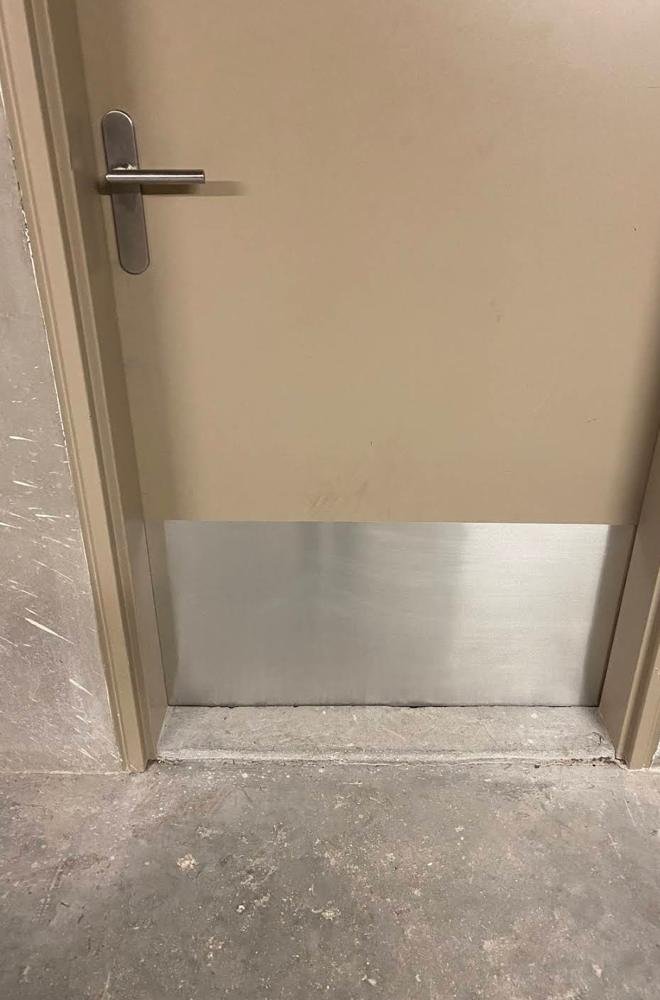 Porte équipée d'une plaque de propreté en inox en partie basse