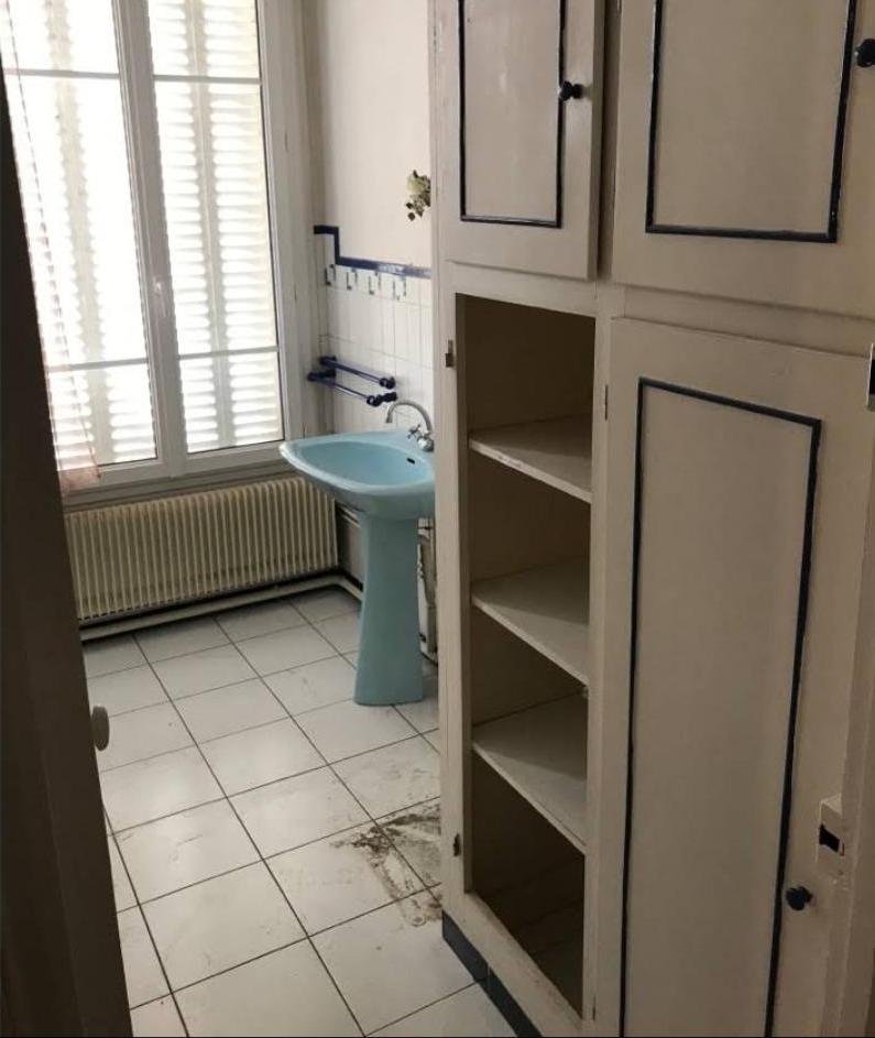 Salle de bain avant travaux : lavabo ancien, placard vétuste